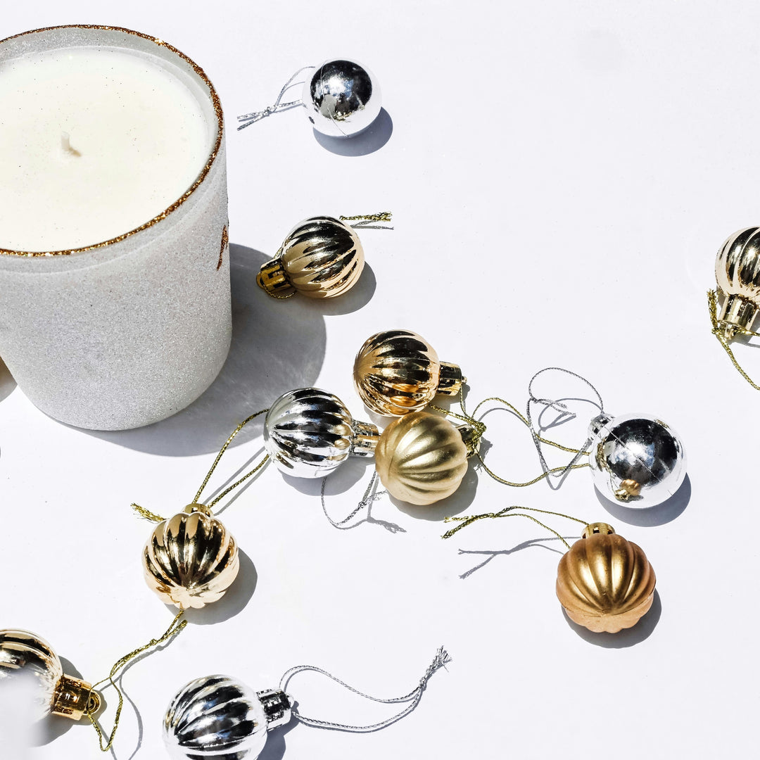 A Candle and Golden and Silver Christmas Baubles