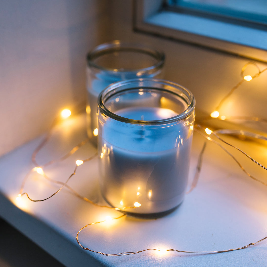 Lighting ferry light around a soy candle jar on window sill