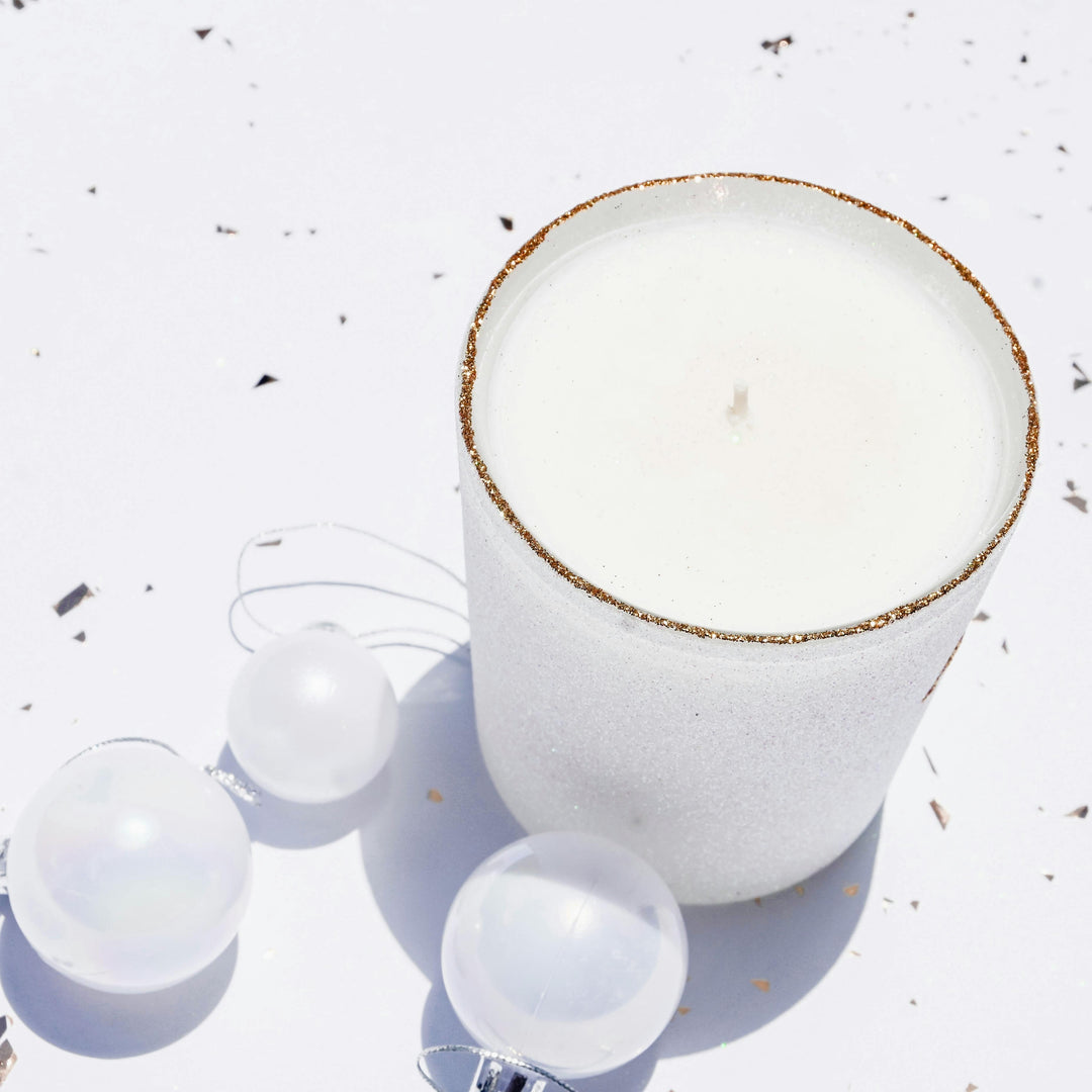 A white Candle and Christmas Baubles